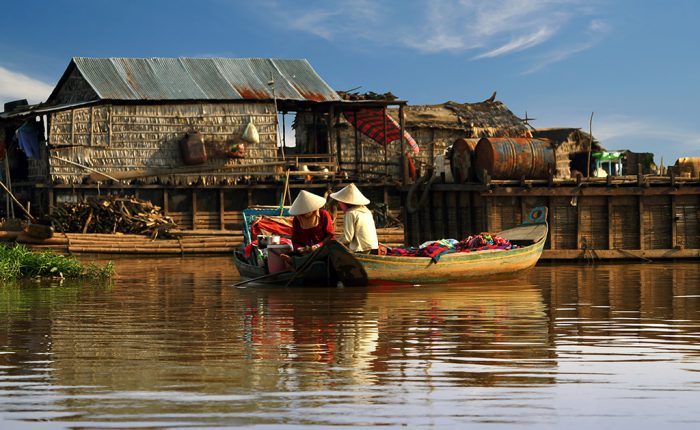 Local boat on the Tonle Sap lake surrounded by floating and stilted villages