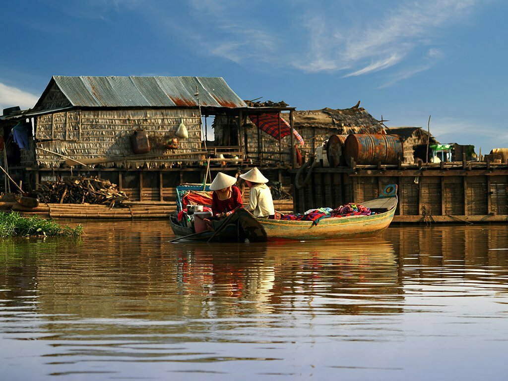 Local boat on the Tonle Sap lake surrounded by floating and stilted villages
