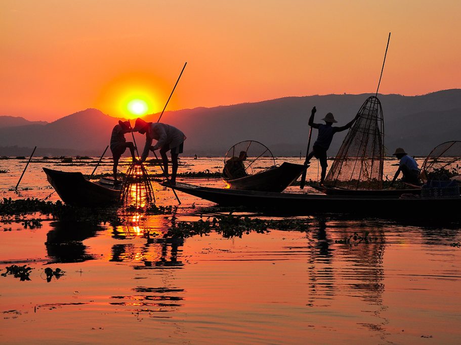 Burmese fishermen catching fishes during sunset on Inle Lake