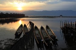 Boats decked on Inle Lake during sunrise