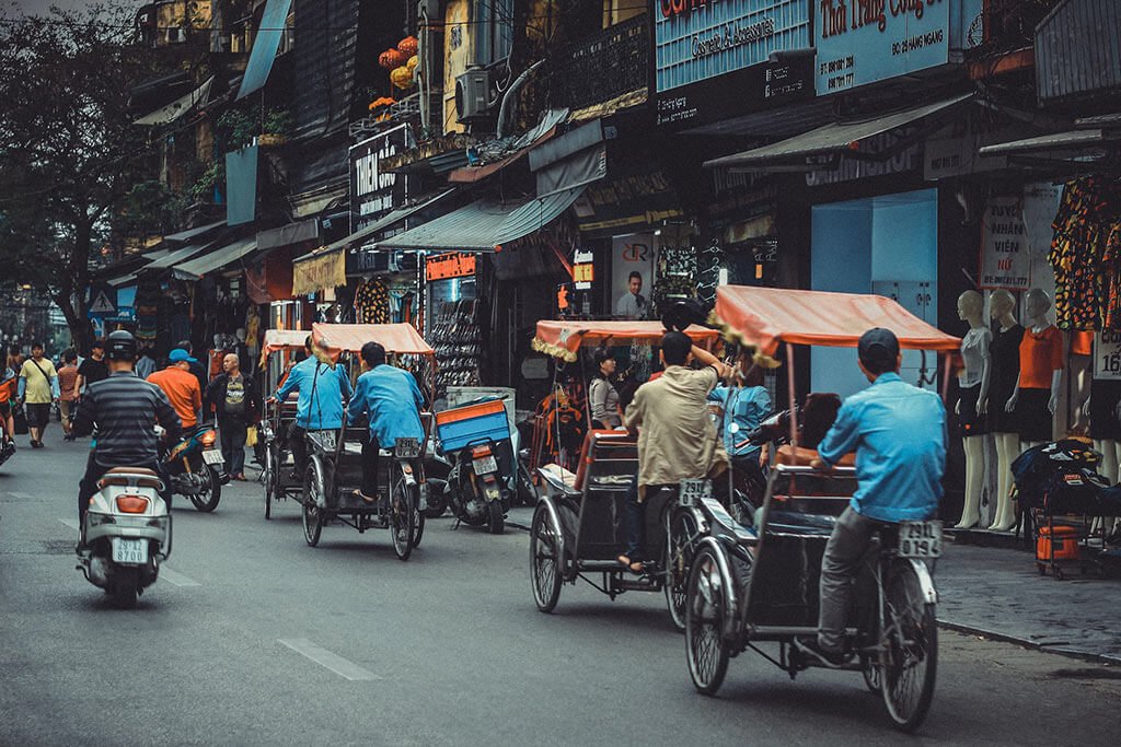 Traditional Vietnamese bicycle rickshaws navigating the busy streets of Hanoi